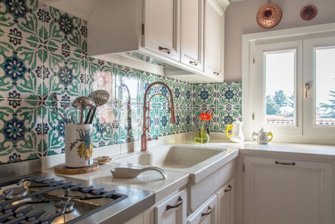 Una cucina sincera, una stanza che si manifesta per quello che è, con materiali che non temono il tempo: le ceramiche di Vietri a rivestimento e la pietra mediterranea a pavimento e top cucina.