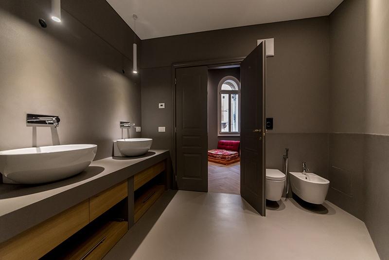 La resina di Kerakoll Design House è la protagonista di questo bagno. L'utilizzo della resina in questo caso, nasce dall'esigenza di realizzare una superficie continua, unica, che dal pavimento sale sulle pareti, sui top lavandino in alcuni casi, nel rivestimento della doccia, sul soffitto e sulla porta.
